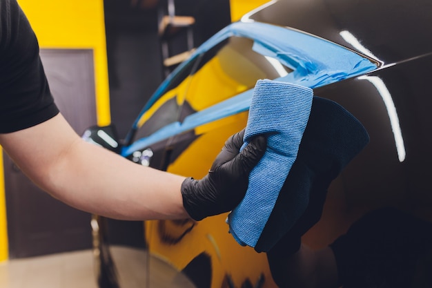 Dettagli auto - mani con lucidatore orbitale nell'officina riparazioni auto.