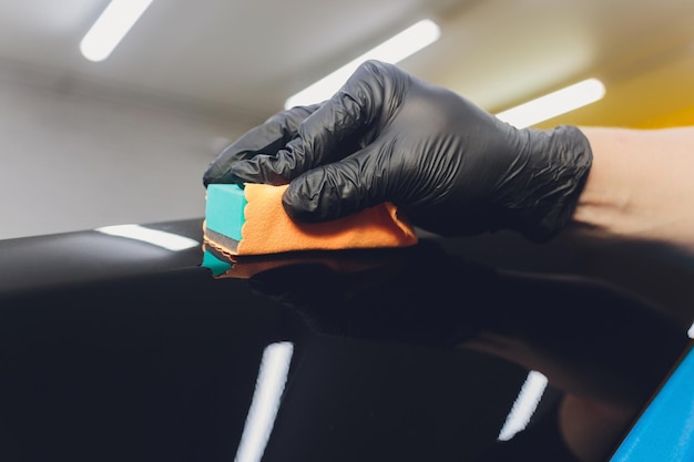 Car detailing Man applies nano protective coating to the car Selective focus