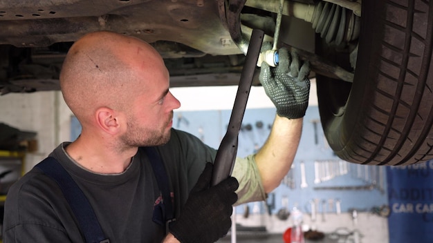 自動車整備士が車の自動車修理工場を点検し、トランスミッションを壊す車の診断
