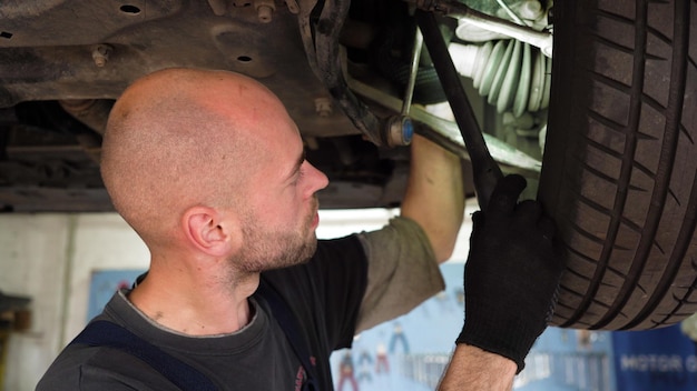 Diagnostica dell'auto un meccanico automobilistico ispeziona un'officina di riparazione auto che rompe la trasmissione