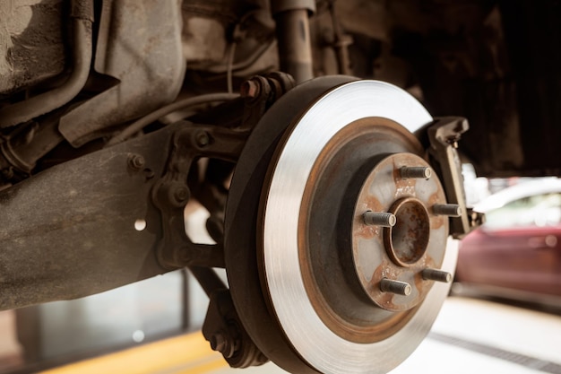 Car disc brake system Car suspension in process of new tire replacement at garage workshop Car disc