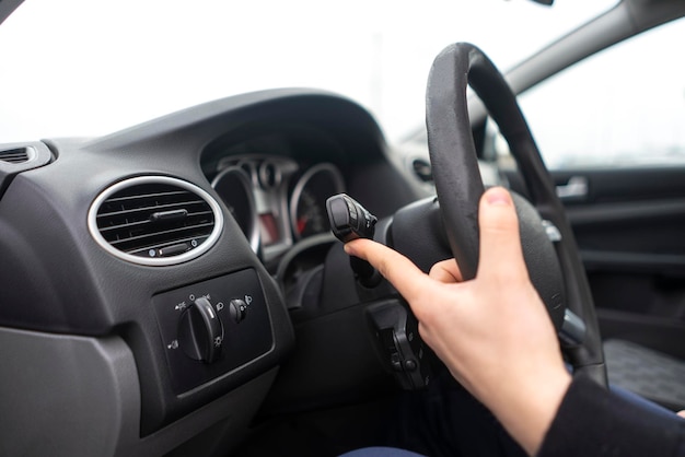 A car driver hand push the button and activate windscreen wipers