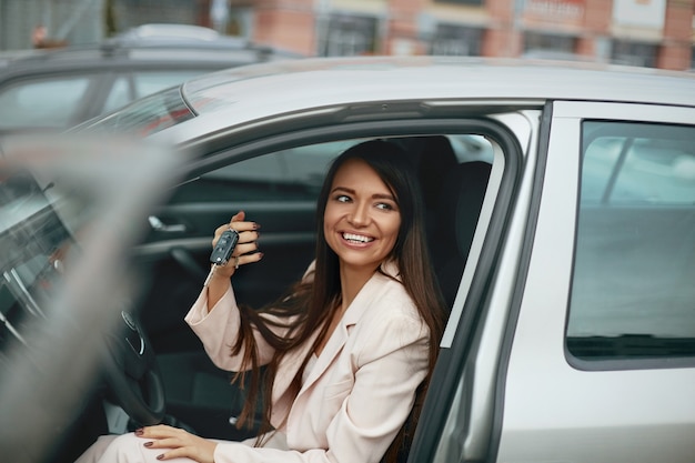 Car driver woman smiling showing new car keys