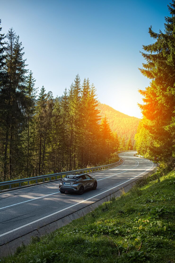 A car driving on asphalting serpentine road in forest mountains