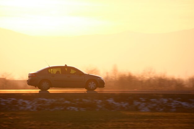 Car driving fast on intercity road at sunset Highway traffic in evening