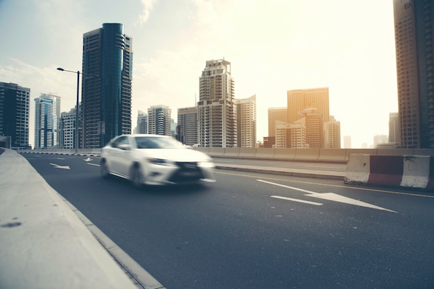 Car driving on road with high buildings