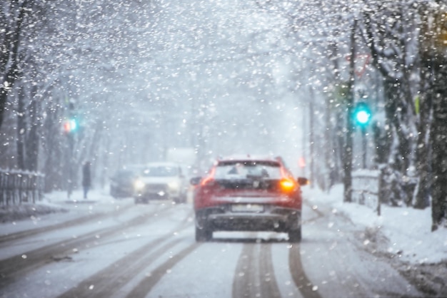 雪に覆われた都会の通りを運転する車