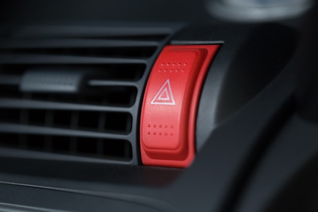 Car emergency light button red with triangle sign in vehicle dashboard for driver