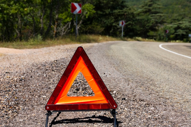 A car emergency stop sign is installed on the road. Danger on the road, warning.