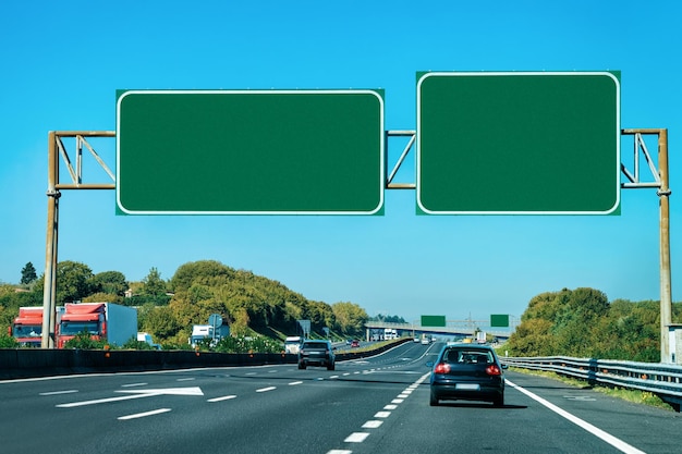 Car and empty green traffic signs on the road in Italy