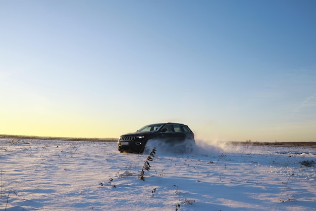 Car in the field in winter Offroad winter snow drifts Extreme sport entertainment