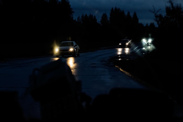 Photo car front window with raindrops and road with cars at night
