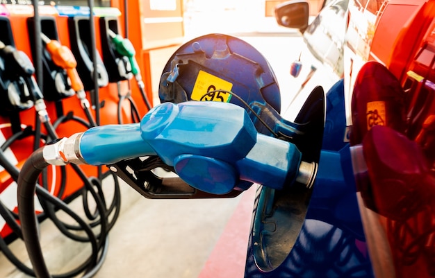 Foto rifornimento dell'auto alla stazione di servizio rifornimento di carburante con benzina benzina pompa benzina che riempie l'ugello del carburante