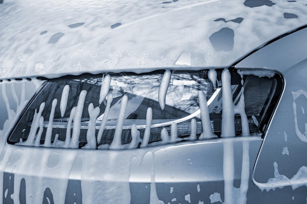 Car headlight in foam outdoor car wash