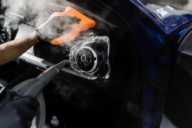 Portrait of worker use car interior steam cleaner. Vapor sterilization  Stock Photo by svitlanah