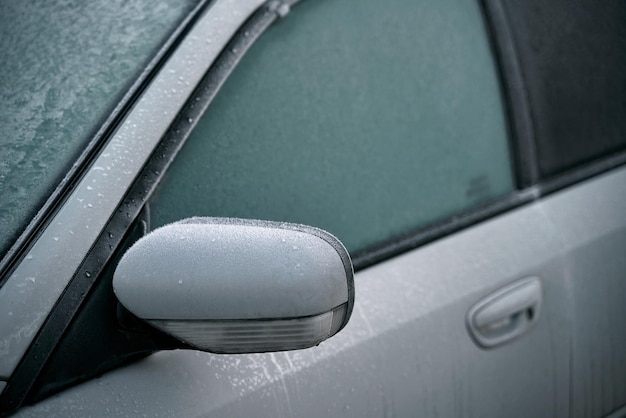 Car is covered with frost cold morning with a vehicle parked outside during night