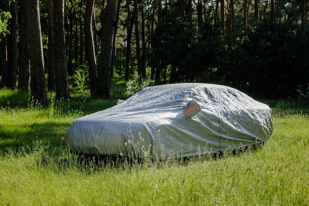 The car is in the parking with auto cover from the sun Protection from heating the car