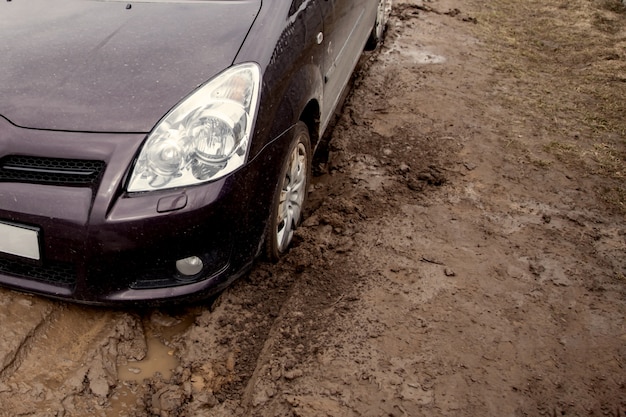 The car is stuck on a bad road in the mud