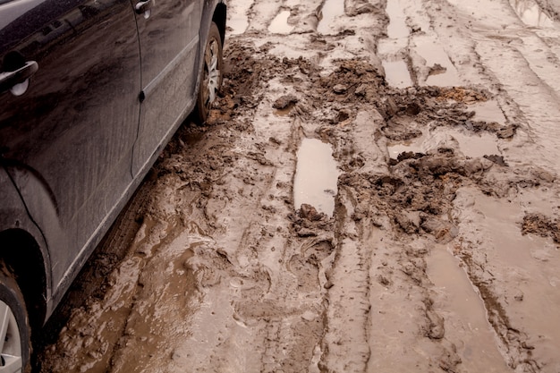 The car is stuck on a bad road in the mud