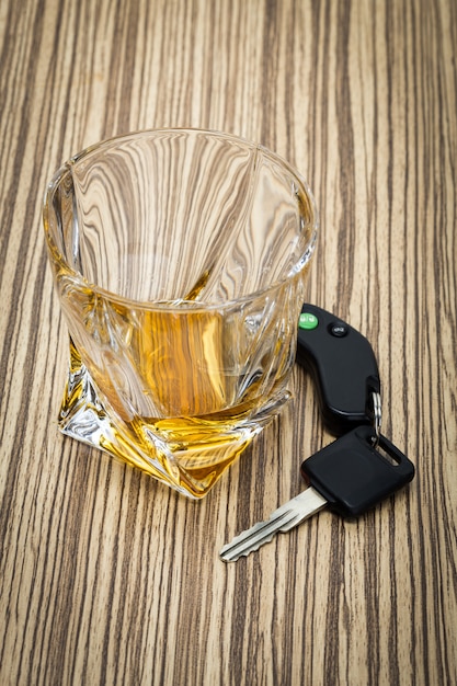 Car key on the bar with spilled alcohol