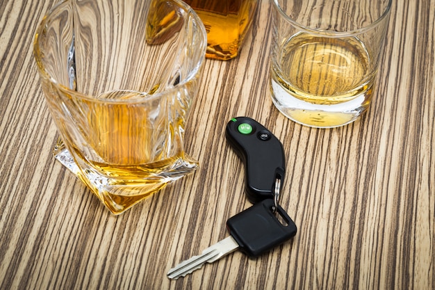 Car key on the bar with spilled alcohol