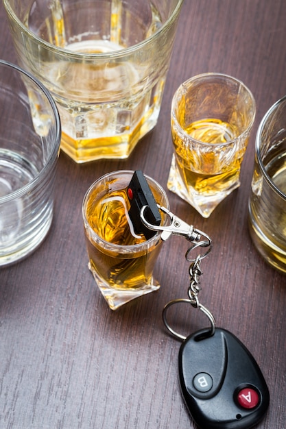 Car key on the bar with spilled alcohol