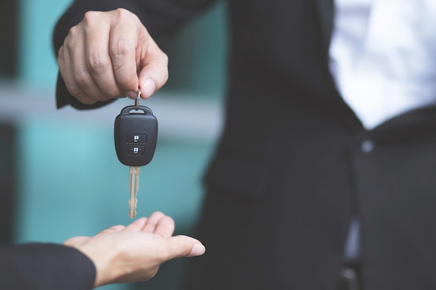 Car key, businessman handing over gives the car key to the other woman 