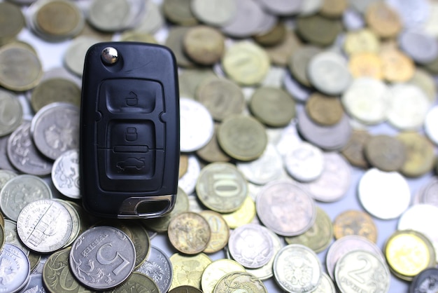 Car key and coin on background