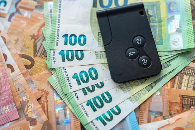 Car key on euro money rent or buy auto concept saving