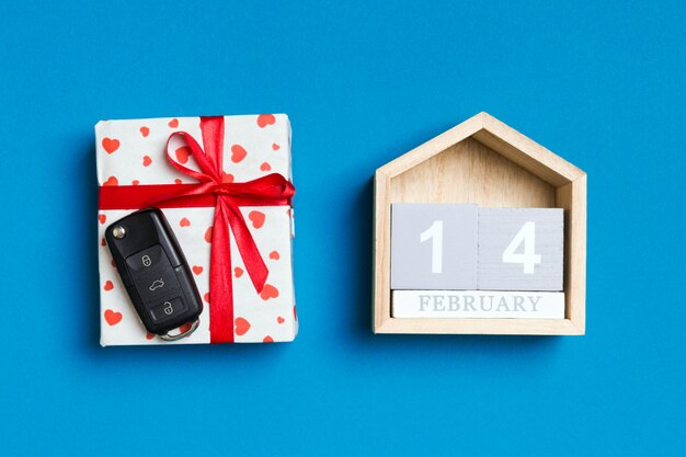 Car key in a gift box with red hearts and festive calendar