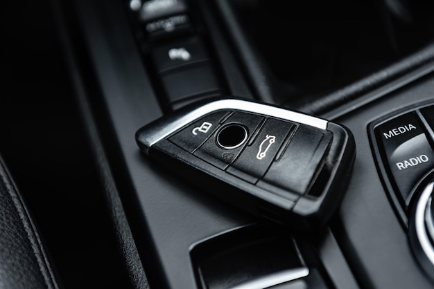 Car key remote in black leather interior. Start engine key.