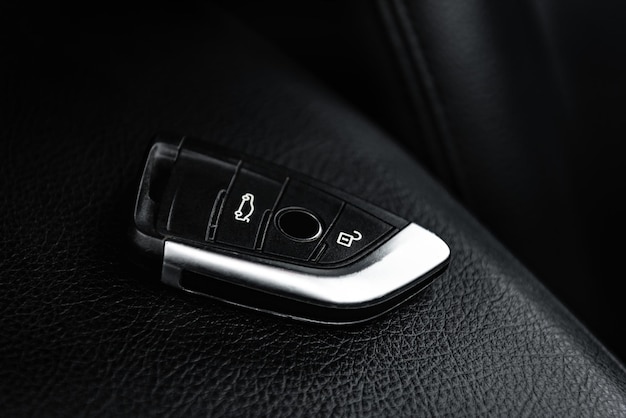 Car key remote in black leather interior. Start engine key.