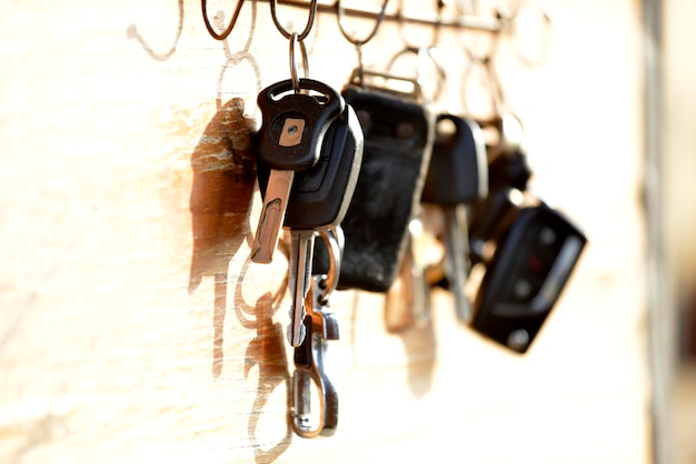 Car key and remote controls are hanging on a wooden board