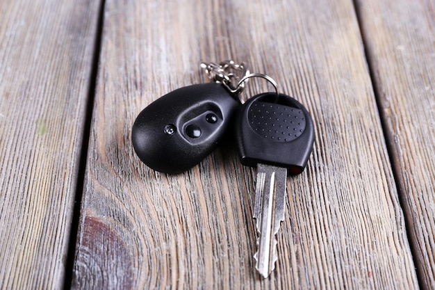 Car key with remote control on wooden table closeup