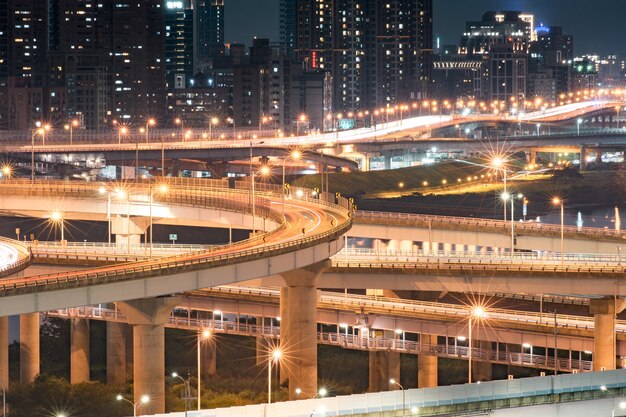 Sentieri luminosi per auto del nuovo ponte di taipei - ponte occupato di taipei dopo l'orario di lavoro