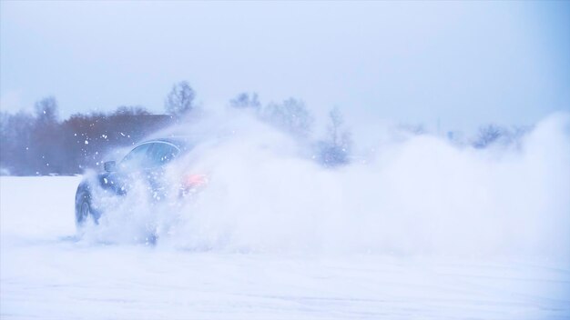 Photo car making uturn in the snow sports car drives in the snow blue crossover does tricks in the snow