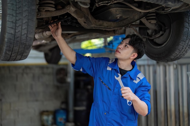 修理サービスステーションで持ち上げられた自動車の自動車整備士の車のサスペンションの詳細