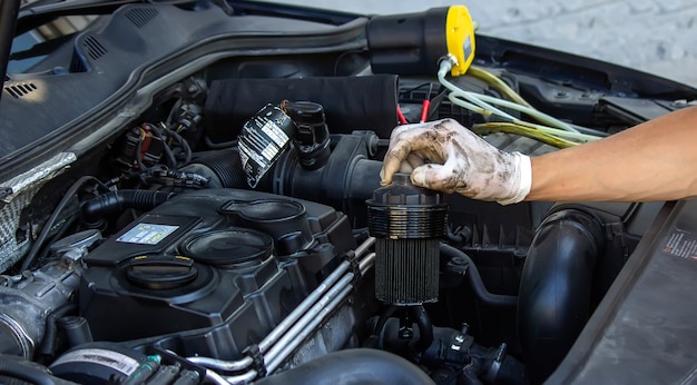 Car mechanic changing oil - model and oil motion blurred.