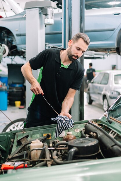 Autofficine che controlla il livello dell'olio