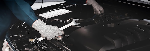 A car mechanic is doing a car repair in a repair shop