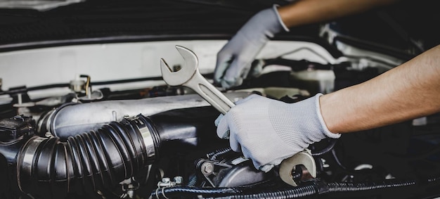 A car mechanic is doing a car repair in a repair shop