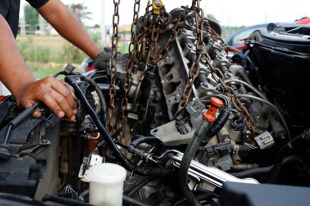 Автомеханик ремонтирует автомобильный двигатель