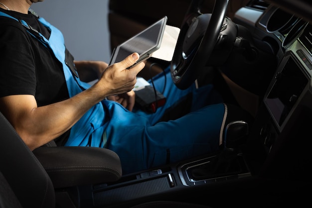 Car mechanic maintains the vehicle with the help of diagnostic modern computer equipment car service