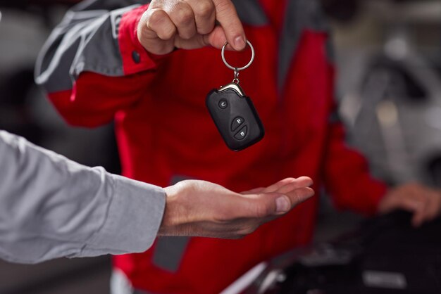 Meccanico di automobile che passa le chiavi dell'auto al cliente