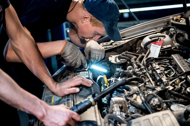 Car mechanic repair engine at service station