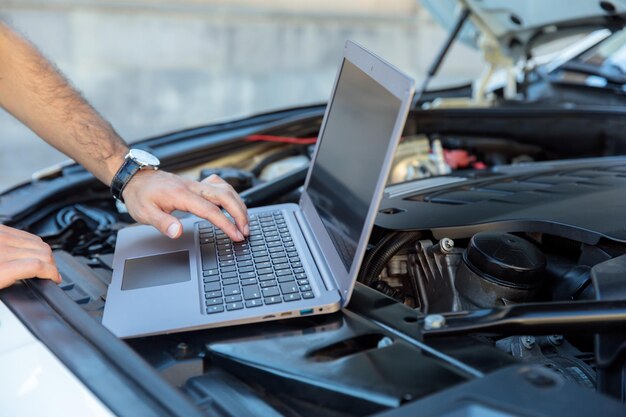 Photo car mechanic using a computer laptop