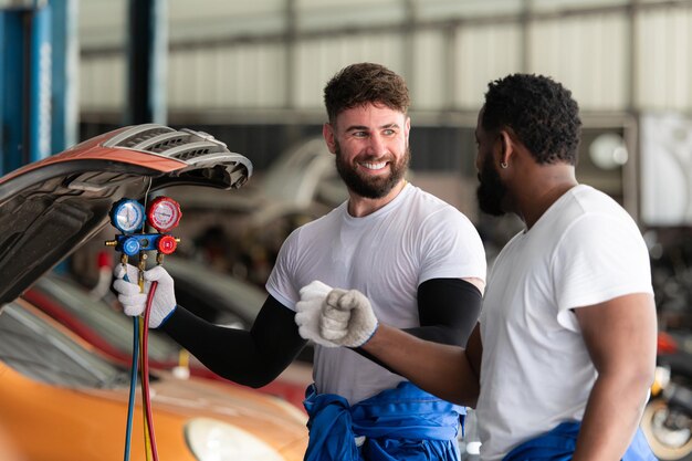 Car mechanic working in an auto repair shop inspecting the operation of the cars air conditioner