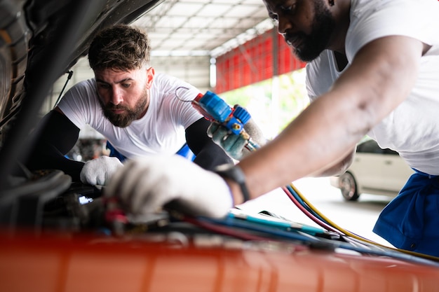 Car mechanic working in an auto repair shop inspecting the operation of the cars air conditioner