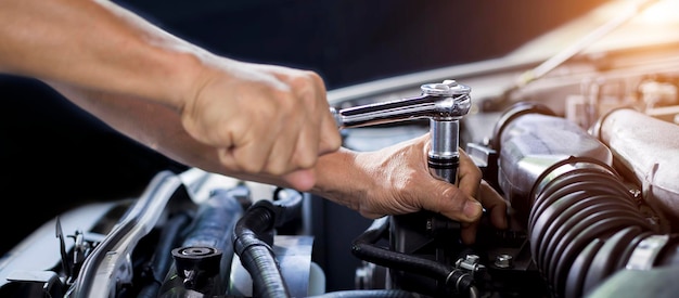 Car mechanic working on car engine car maintenance concept