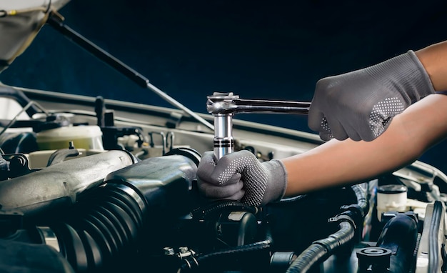 Car mechanic working on car engine car maintenance concept